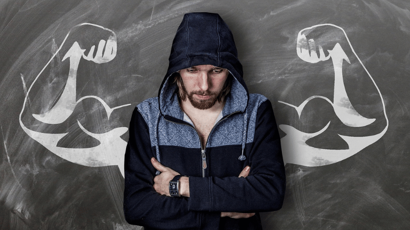 腕を組んで考えている男性