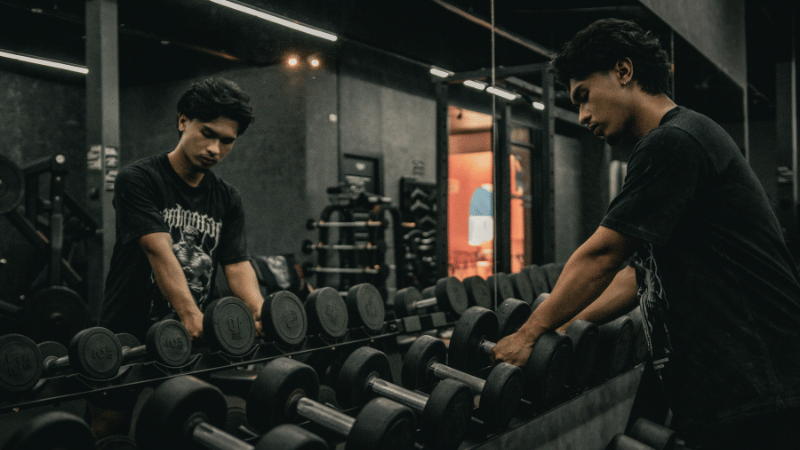 ダンベルを手に取り筋トレしようとしている男性