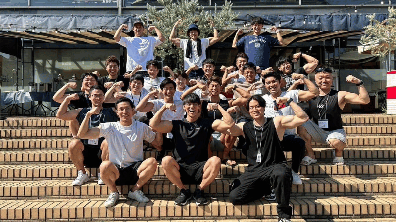 笑顔でマッスルポーズを取るCOMPASSメンバー