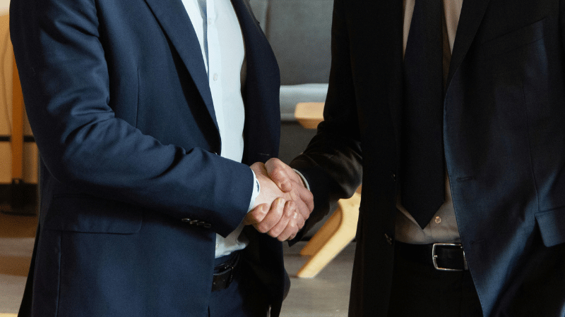 握手をしているスーツの男性2人